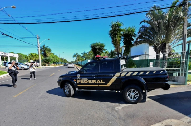 Un véhicule de la police fédérale quitte la résidence où vit l'ancien président brésilien Jair Bolsonaro après une perquisition, le 3 mai 2023 à Brasilia
