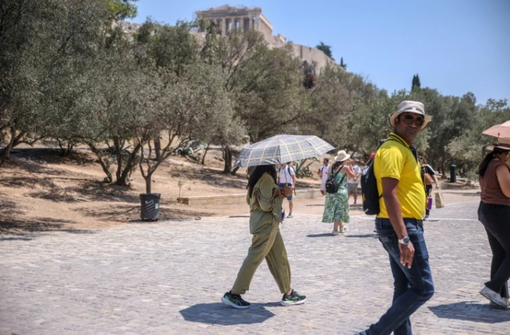 Des touristes près de l'Acropole à Athènes, le 12 juillet 2024