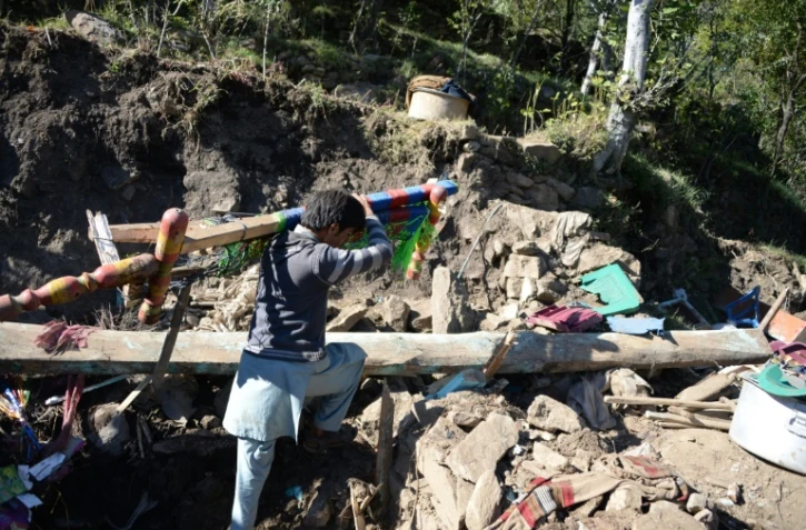 Un survivant du tremblement de terre récupère des affaires dans les ruines de sa maison, dans le district de Shangla dans le nord du Pakistan, le 28 octobre 2015