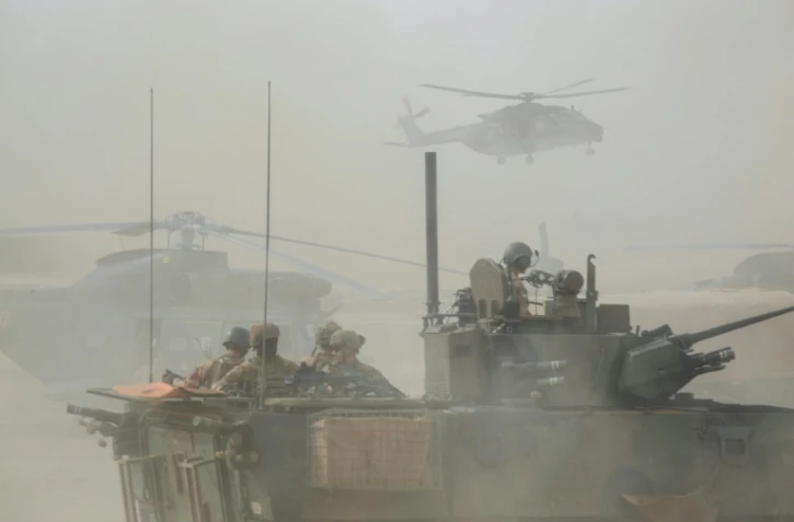 Un blindé et des hélicoptères militaires français de l'opération Barkhane le 27 mars 2019 dans la région malienne de Gourma