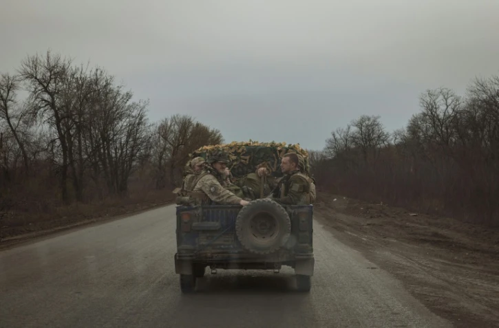 Des soldats ukrainiens à l'arrière d'un véhicule militaire sur une route près de Tchassiv Iar, dans la région de Donetsk, le 2 avril 2024