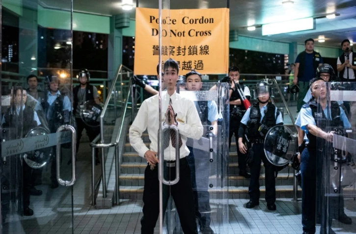 Un agent de sécurité ferme les portes d'une galerie commerciale lors d'une manifestation à Hong Kong, le 13 juillet 2019