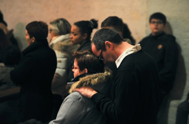A Surgères, dans l'ouest de la France, le 12 février 2016, des gens assistent à une messe en hommage aux victimes d'un accident de car survenu la veille
