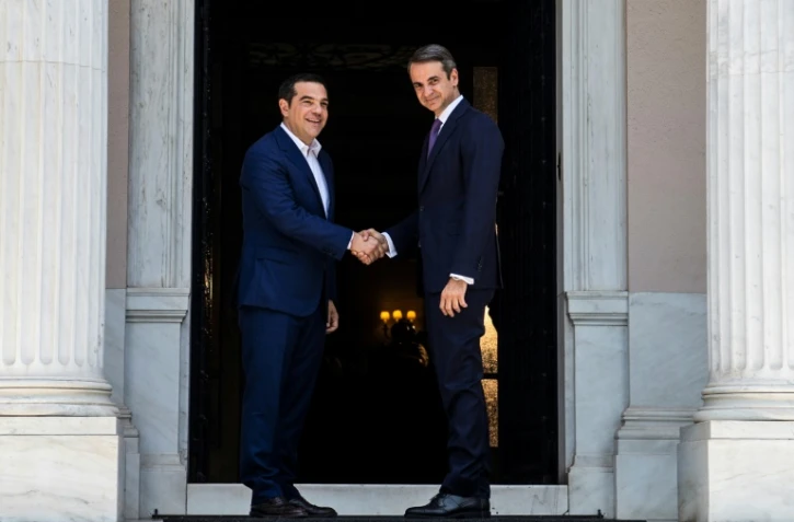 Le nouveau Premier ministre grec Kyriakos Mitsotakis (g) et son prédécesseur, Alexis Tsipras, se serrent la main après leur rencontre à la villa Maximos, le 8 juillet 2019 à Athènes