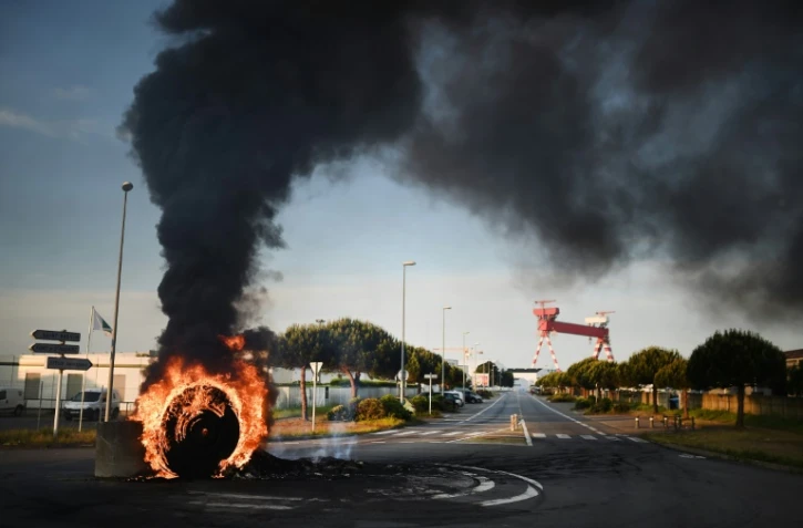 Des grévistes brûlent un pneu pour bloquer l'accès au port de Saint-Nazaire le 24 mai 2016