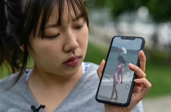 La militante chinoise anti-anorexie Zhang Qinwen montre une photo d'elle il y a trois ans sur son portable, quand elle souffrait encore de désordres alimentaires, le 18 mai 2021 à Shanghai 