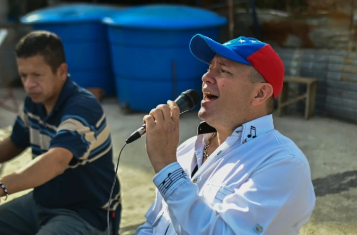 Ruben Pena anime depuis le toit de son immeuble à Caracas, le 18 juillet 2020 une "émission" de chansons pour égayer la vie des habitants