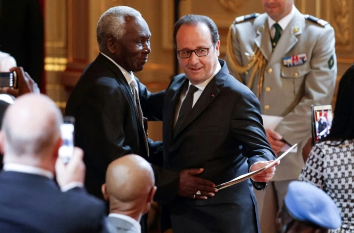 Le président François Hollande (d) lors d'une cérémonie réintégrant 28 tirailleurs sénégalais dans la nationalité française, le 15 avril 2017 à Paris