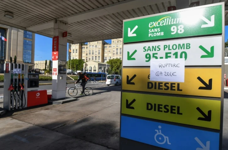 Un cycliste passe à côté d'une station essence à Montpellier le 4 décembre 2018