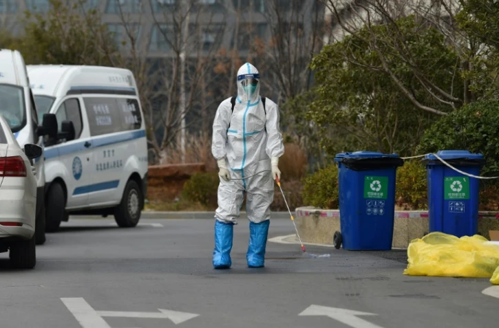 Un homme désinfecte les environs d'un hôtel dans la ville chinoise de Nanjing le 28 décembre 2021