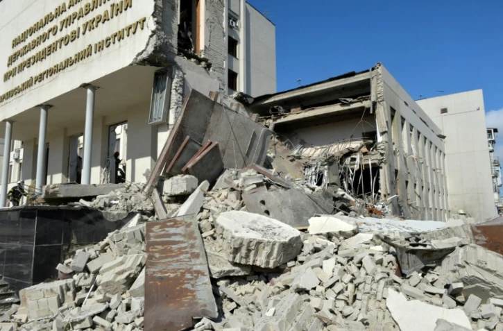 Des secouristes dans les décombres d'un immeuble administratif bombardé à Kharkiv en Ukraine, le 18 mars 2022