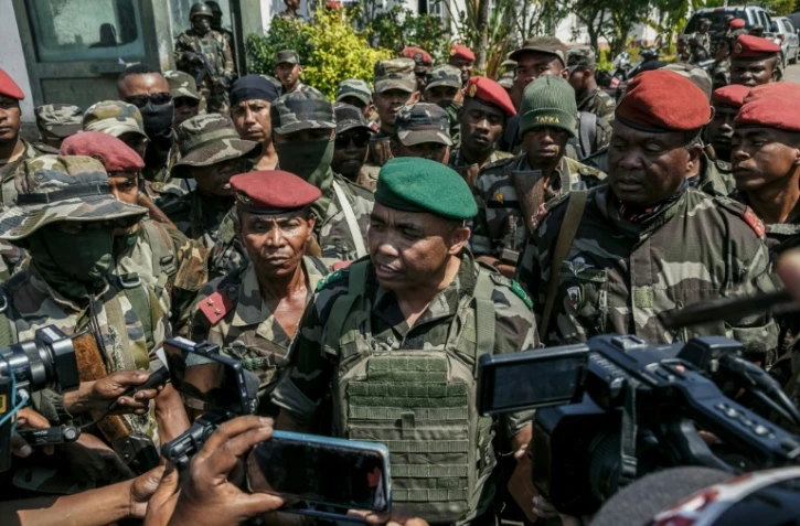 Des membres d'une unité de l'armée malgache parlent à la presse près de leur camp situé près d'Antananarivo, le 11 octobre 2025