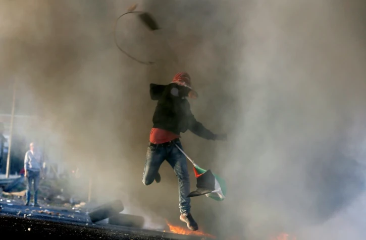 Un palestinien jette des pierres avec une fronde pour protester contre l'occupation israélienne à al-Bireh dans la banlieue de Ramallah, le 29 novembre 2015