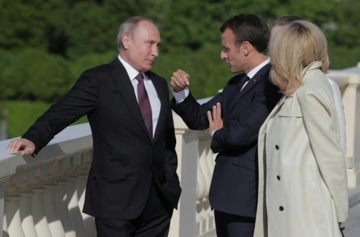 Le président russe Vladimir Poutine avec son homologue français Emmanuel Macron et son épouse Brigitte le 24 mai 2018 à Saint-Pétersbourg