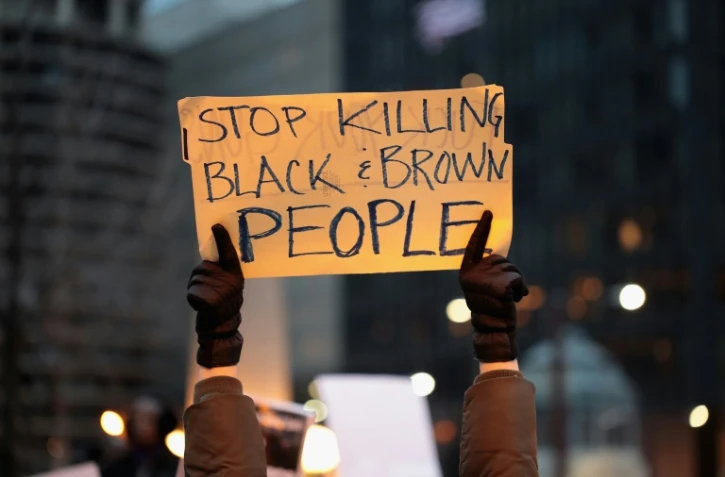 Un manifestant à Chicago le 2 avril 2018, proteste contre les meurtres de Noirs par la police américaine  