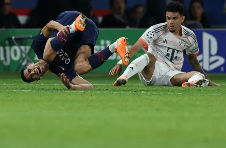 Le défenseur du Paris SG Achraf Hakimi (G) blessé lors de la défaite contre le Bayern Munich (2-1) à la suite d'un tacle de l'attaquant Luis Diaz (D), le 4 novembre 2025 au Parc des Princes