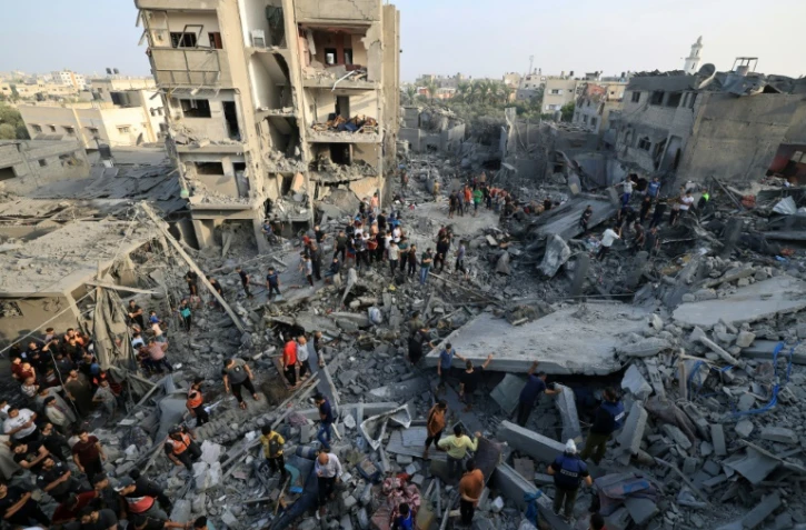 Des Palestiniens fouillent les décombres d'immeubles touchés par une frappe israélienne sur le camp de réfugis de Maghazi, dans le centre de la bande de Gaza, à la recherche de survivants le 5 novembre 2023