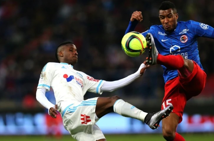 Le milieu de Marseille Bouna Sarr (g) à la lutte avec le défenseur de Caen Emmanuel Imorou au stade Michel d'Ornano, le 17 janvier 2016