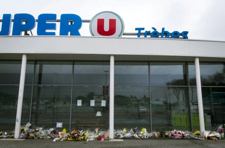 Des fleurs déposées en mémoire des victimes de l'attentat devant le supermarché Super U de Trèbes dans le sud de la France, le 6 avril 2018