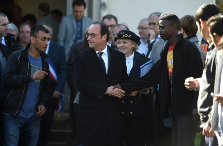 Le président François Hollande entouré de migrants lors d'une visite le 29 octobre 2016 au Centre d'Acceuil et d'Orientation de Doué-la-Fontaine