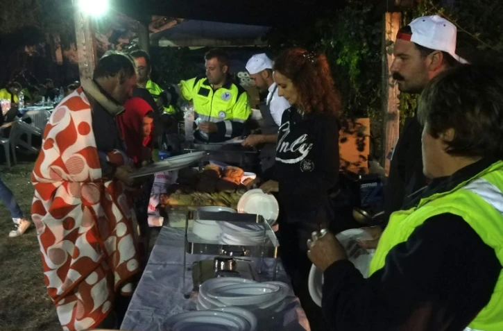 Des volontaires servent le dîner le 25 août 2016 à des habitants d'Illica, un hameau d'Accumoli (Latium) dévasté par un séisme la veille