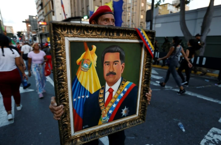 Un partisan du président vénézuélien Nicolas Maduro tient son portrait lors d'une marche de soutien à Caracas le 17 août 2024