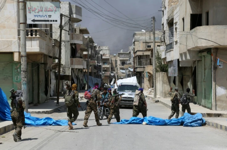 Des membres des forces démocratiques syriennes (FDS) patrouillent dans la ville de Minbej, le 7 août 2016 à la recherche de combattants de l'EI