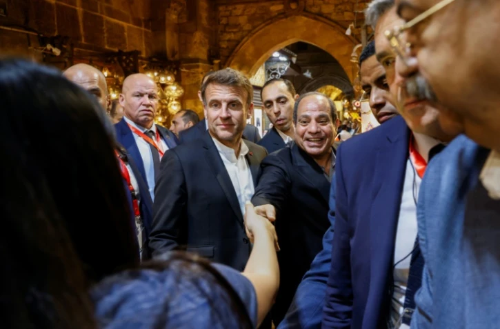 Le président français Emmanuel Macron (au centre gauche) et son homologue égyptien Abdel Fattah al-Sissi (au centre droit) au souk du Caire, le 6 avril 2025