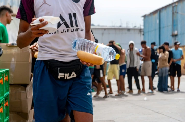 Des bénévoles de l'ONG Luna Blanca distribuent de la nourriture à des migrants sur le site industriel d'El Tajaral à Ceutae, Espagne, le 2 septembre 2026
