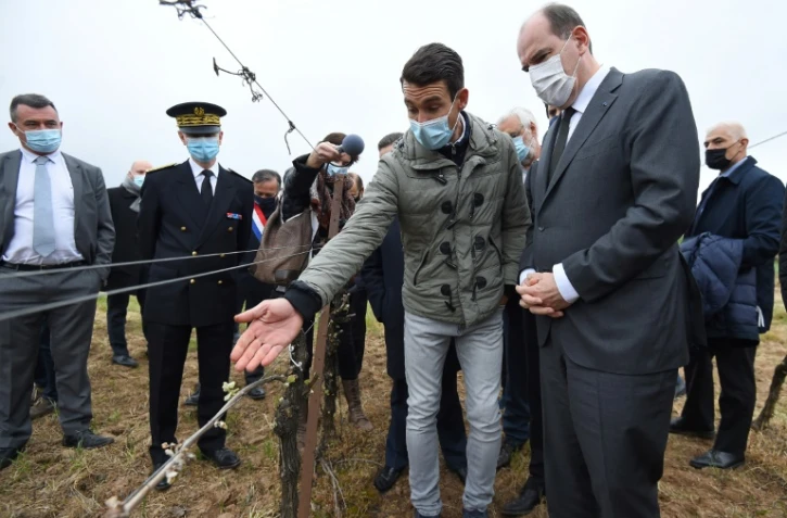 Le Premier ministre Jean Castex (d) constate les dégâts dus au gel auprès d'un vigneron à Montagnac, près de Béziers, le 17 avril 2021