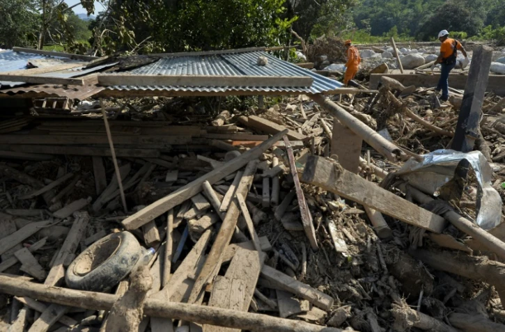 Des membres de la Défense civile au milieu des décombres de maisons détruites par la coulée de boue à Mocoa, le 5a vril 2017 en Colombie