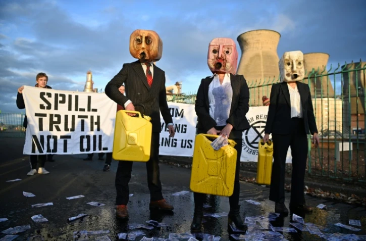 Des militants écologistes d'Ocean Rebellion, dégisés en "Oil heads", manifestent devant la raffinerie de Grangemouth, en Ecosse, en pleine COP26, le 2 novembre 2021
