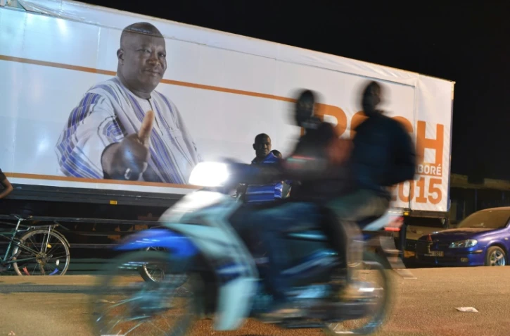 Des militants burkinabè fêtent la victoire à la présidentielle de Roch Marc Christian Kaboré (arrière-plan) à Ouagadougou le 1er décembre 2015