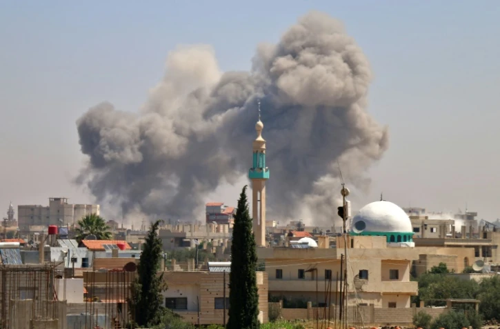 Des colonnes de fumée s'élèvent de la ville rebelle de Nawa, à environ 30 km au nord de Deraa, dans le sud syrien, le 27 juin 2018 lors de frappes aériennes attribuée au régime