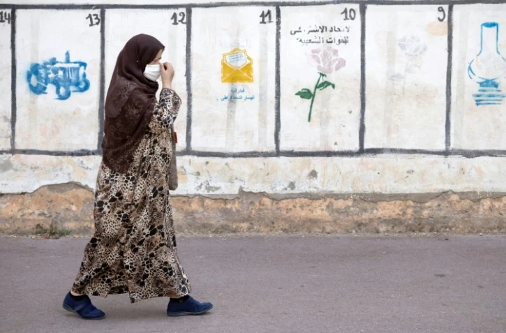 Une femme passe devant les symboles de partis politiques concourant aux élections marocaines, à Rabat, le 26 août 2021