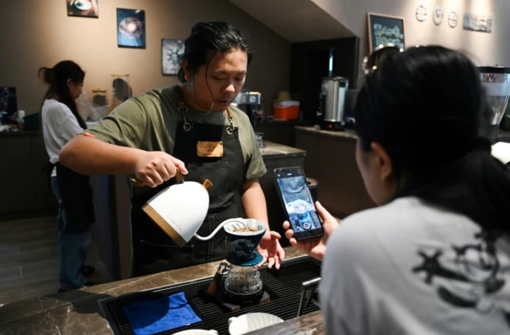 Liao Shihao sert du café à un client à la plantation de café Xiaowazi, le 1er avril 2025 à Pu'er, dans la province du Yunnan, dans le sud-ouest de la Chine
