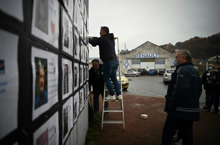 Des salariés de l'équipementier SAM affichent les portraits des membres du personnel sur les murs de l'usine, à Viviez, dans l'Aveyron, le 26 novembre 2021