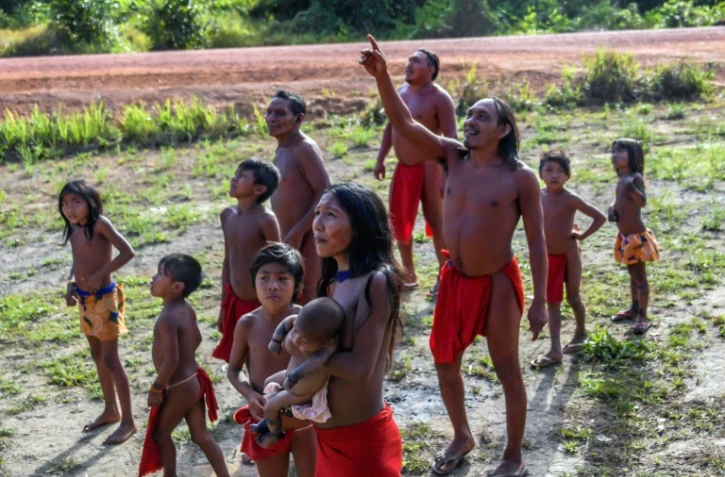 Des Indiens Waiapi regardent un avion survoler leur village de Manilha, au coeur de la forêt amazonienne, le 15 octobre 2017