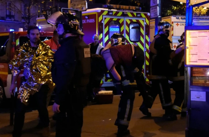 Un pompier transporte une victime des attaques survenues dans le centre de Paris, le 13 novembre 2015