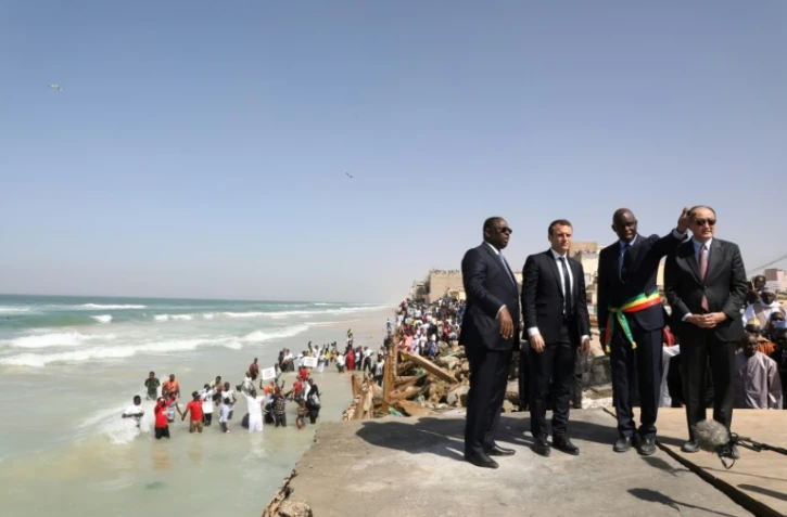 Le président sénégalais Macky Sall (à gauche), son homologue français Emmanuel Macron et le maire de Saint-Louis Cheikh Mamadou Abiboulaye Dieye devant la mer à Saint-Louis le 3 février 2018, au dernier jour de la visite de M. Macron au Sénégal. 