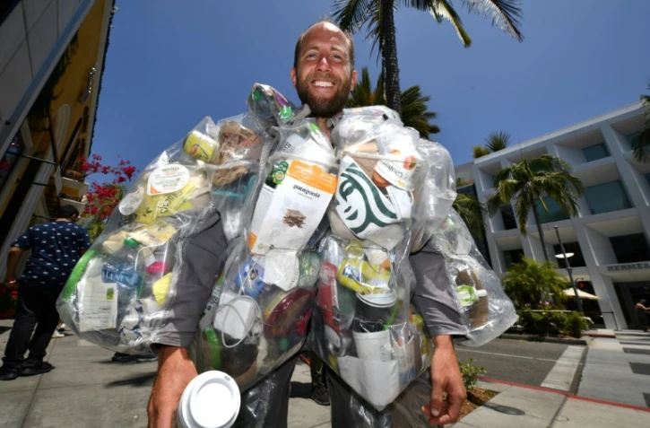 Le militant écologiste Rob Greenfield  porte les déchets qu'il a produits pendant trente jours, dans les rues de Beverly Hills, le 16 mai 2022 en Californie