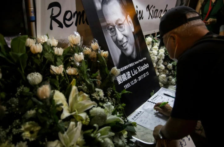 Un homme écrit un message sur le livre de condoléances après la mort du dissident chinois et Nobel de la Paix 2010 Liu Xiaobo, le 13 juillet 2017 à Hong Kong