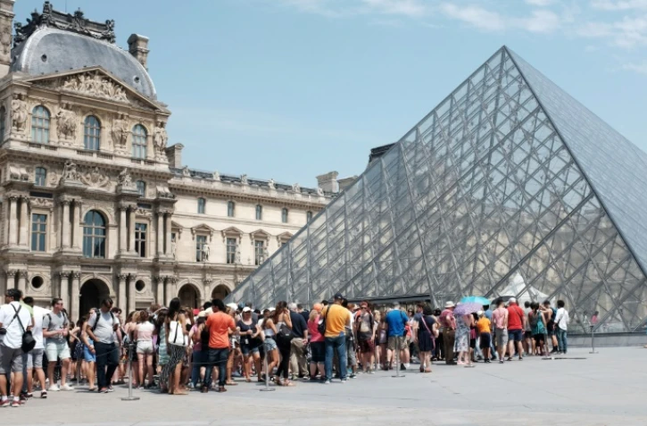 Touristes faisant la queue pour entrer au Louvre, à Paris, le 2 juillet 2015
