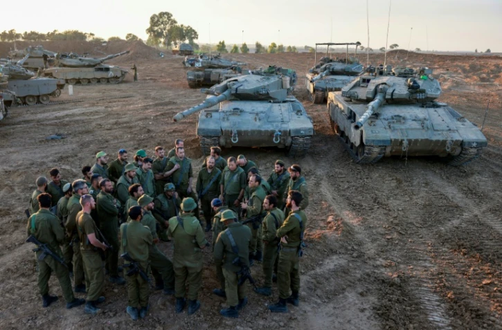 Des soldats israéliens déployés avec leurs chars à la frontière avec la bande de Gaza assistent à un briefing, le 29 novembre 2023