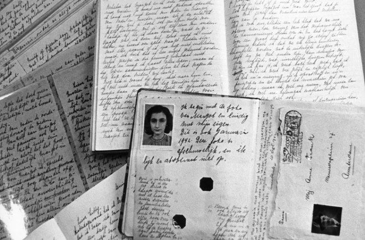 Photo du passeport d'Anne Frank posé sur des cahiers de son journal qu'elle écrivit dans les combles de la maison d'Amsterdam où elle était réfugiée avec ses parents pour échapper aux nazis entre juin 1942 et le 4 août 1944