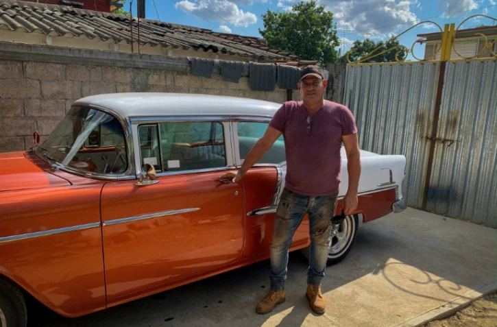 Le carrossier Pedro Manso devant sa Chevrolet BelAir 55 qu'il a restaurée dans son atellier de Placetas, dans la province de Villa Clara, le 24 avril 2021 à Cuba