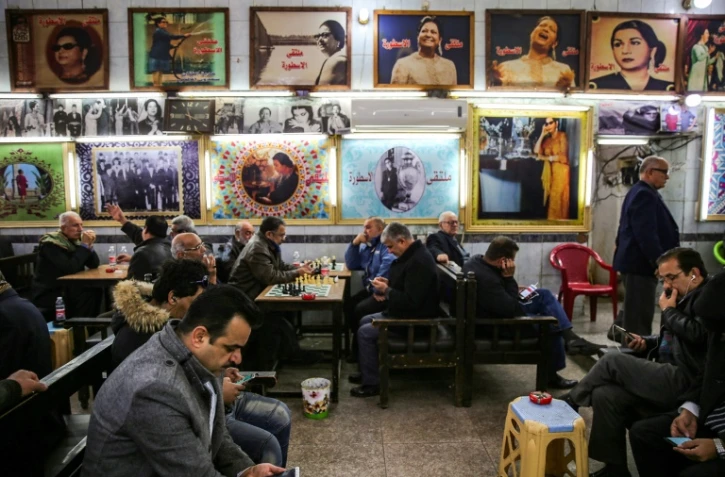 Des Irakiens attablés au café Oum Kalthoum à Bagdad, dans la rue Rachid, sur fond de photos de la diva arabe, le 20 janvier 2019
