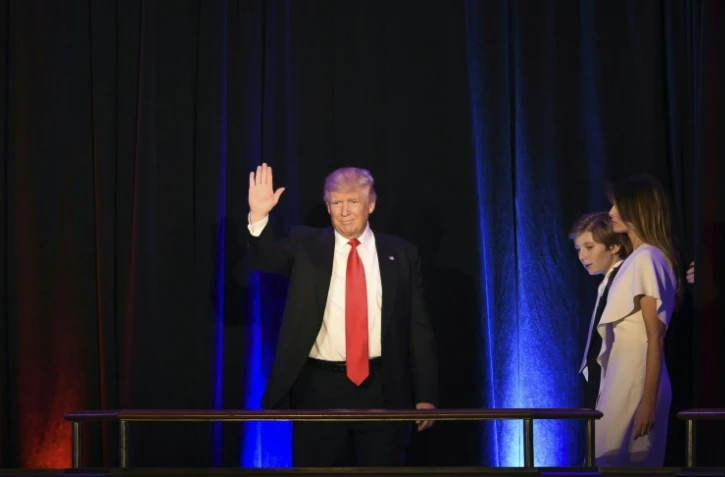 Le président élu Donald Trump, accompagné de son fils Baron et de sa femme Melania, salue ses supporteurs, le 9 novembre 2016 à New York