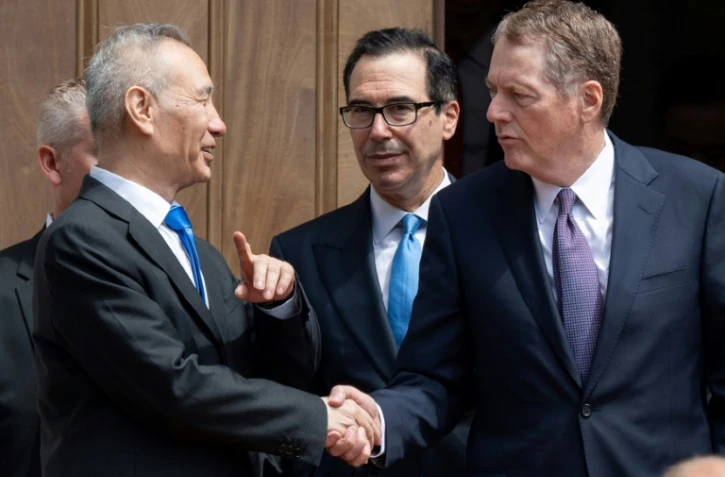 Le vice-Premier ministre chinois Liu He serre la main du représentant au Commerce américain Robert Lighthizer sous le regard du secrétaire au Trésor Steven Mnuchin, le 10 mai 2019 à Washington