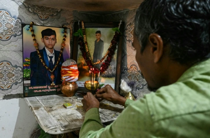 Suresh Patni, père d'Akash Patni, victime du crash du vol 171 d'Air India d'Air India, prie devant les portraits de son fils à son domicile d'Ahmedabad, le 8 novembre 2025 en Inde